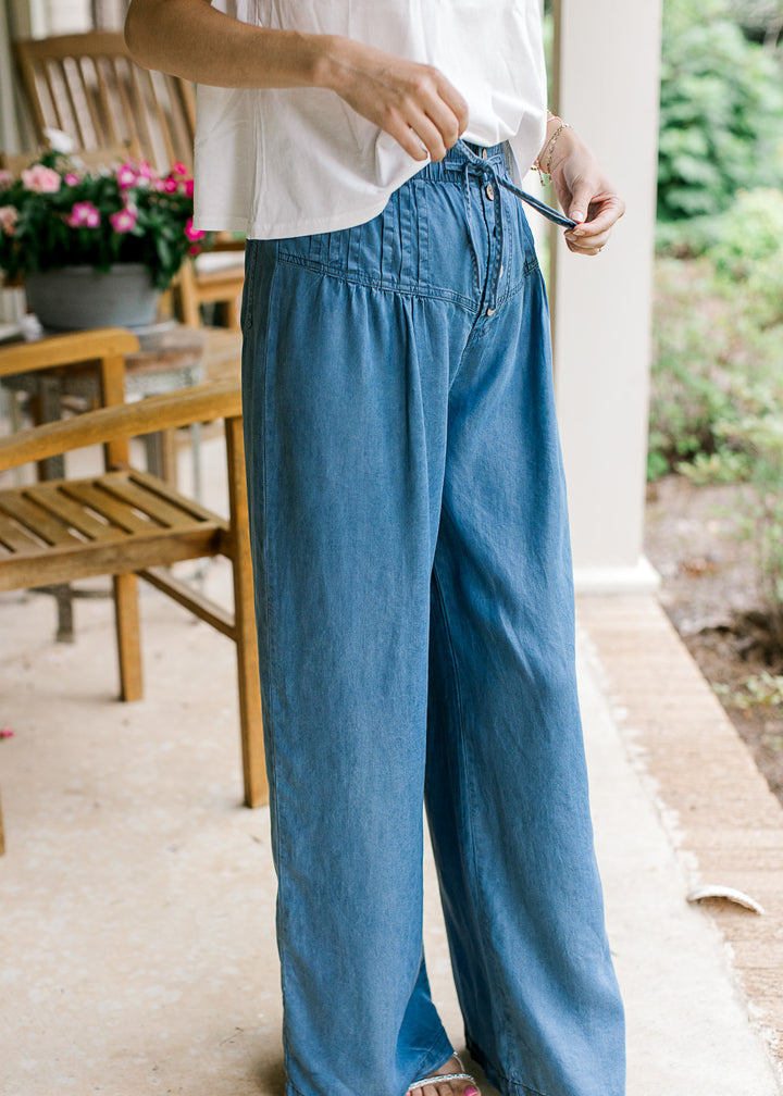 Close up of stitched down pleating, button front and elastic waist with tie on chambray pants.
