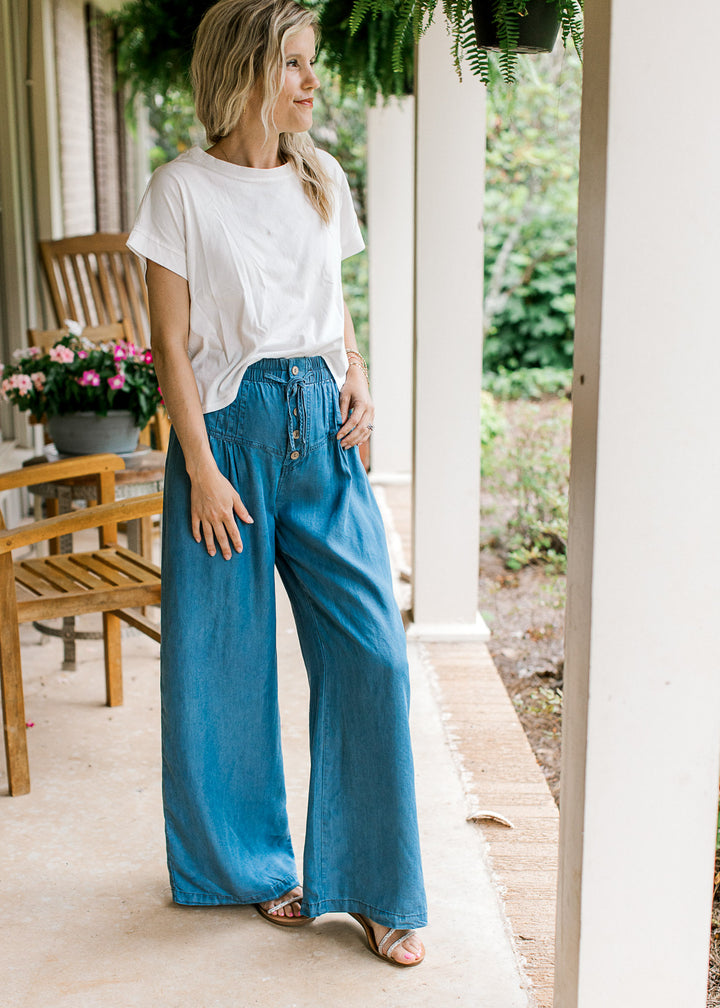 Model wearing chambray wide leg pants with stitched down pleating, button front and elastic waist. 