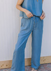 Close up of wide leg, chambray bottoms with elastic waist, tie closure and pockets. 
