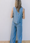 Back view of Model wearing a chambray set with a button up sleeveless top and wide leg bottoms.