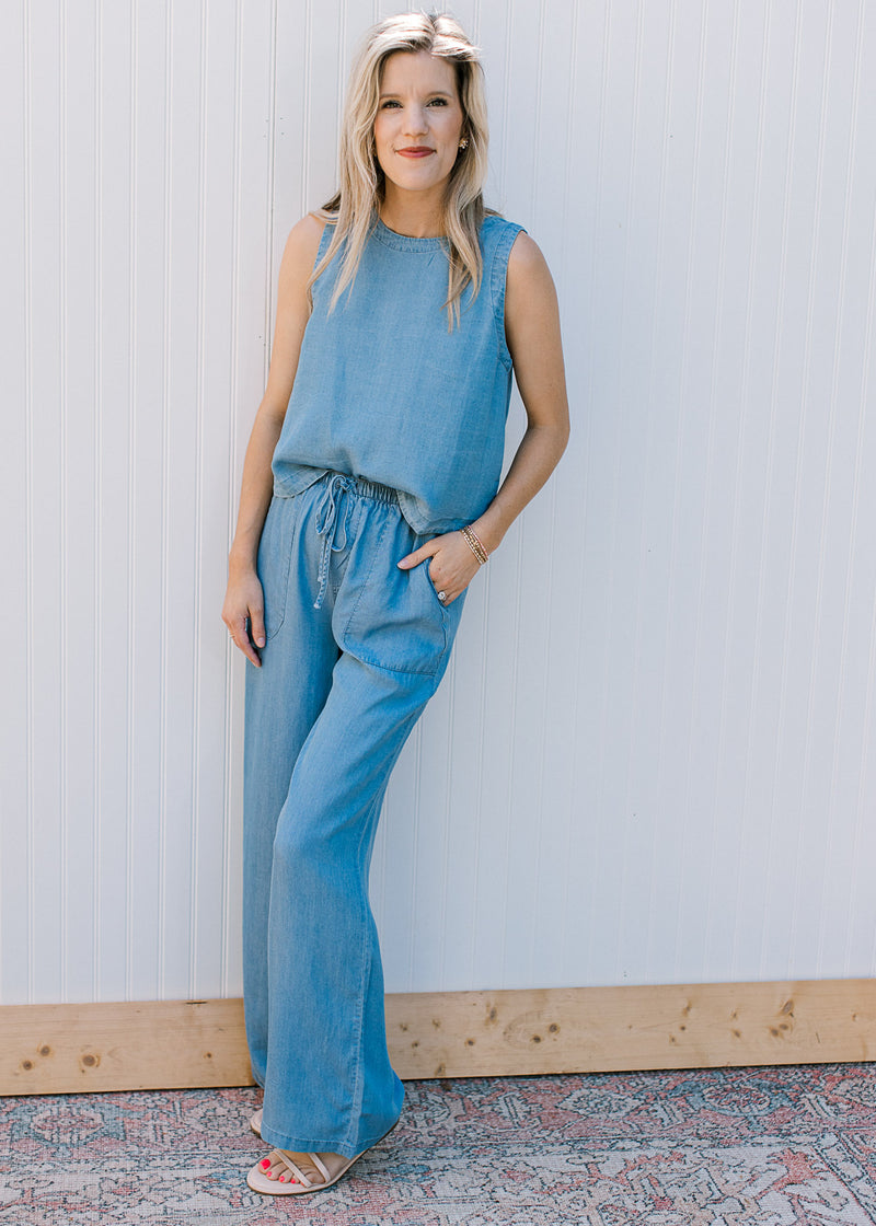 Model wearing sandals and a chambray set with a sleeveless top and wide leg bottoms.