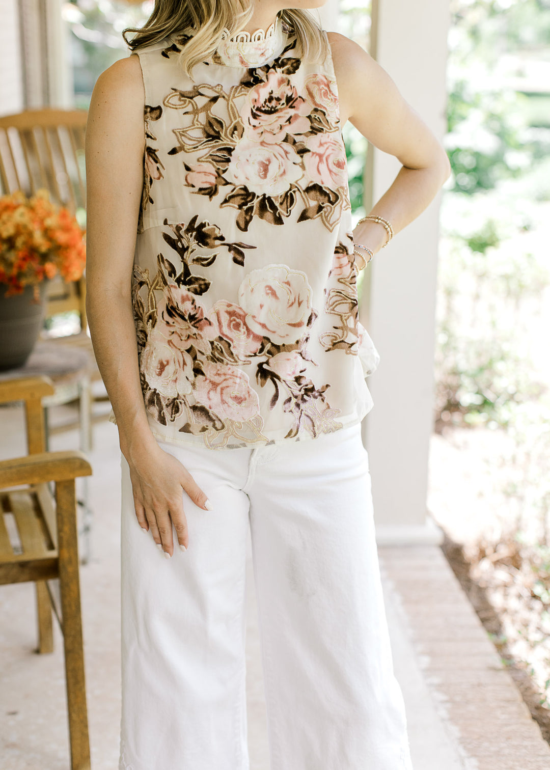 Model wearing an oatmeal top with velvet pink and brown floral and mock neck with cream lace.