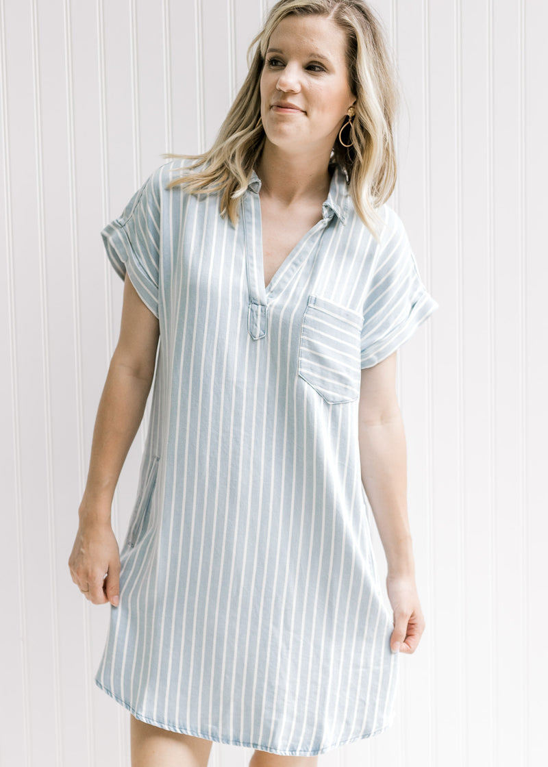 Model wearing a light blue and cream striped v-neck above the knee dress made of lyocell. 
