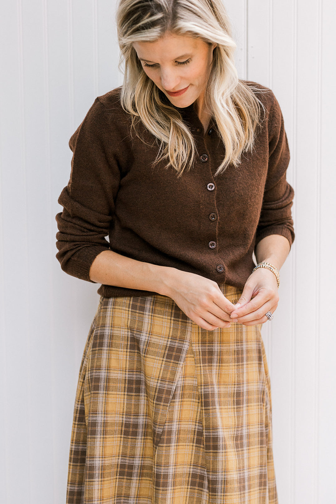 Model wearing an ultra soft brown button front cardigan with long sleeves and a round neck.