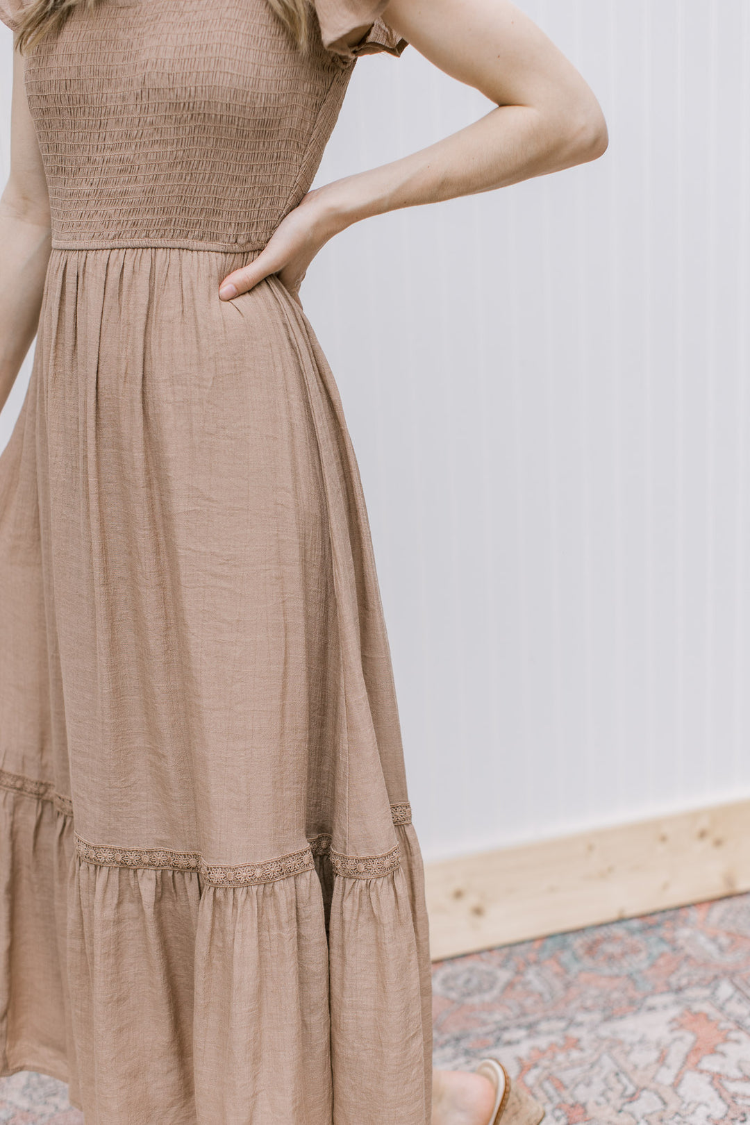 Close up of smocked bodice and lace detail on a light brown midi. 