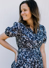 Model wearing a navy midi with white flowers, elastic waist, short sleeves and an elastic waist. 