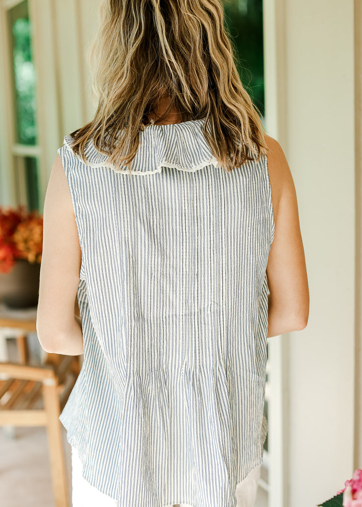 Back view of an off-white and pale blue striped sleeveless top with exaggerated flap collar. 