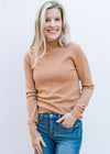 Model wearing jean and a clay colored sweater with long sleeves and a mocked neck.