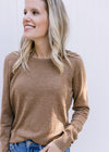 Close up of a Model wearing a camel colored lightweight sweater with a round neck and long sleeves. 