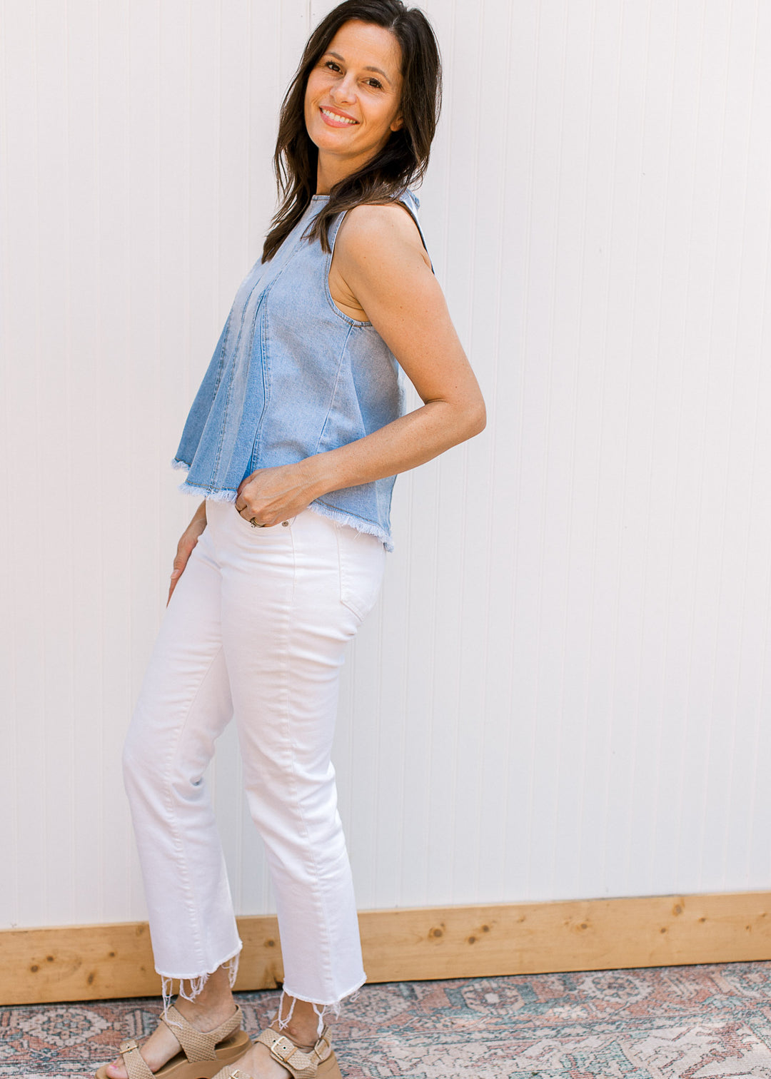 Model wearing white jeans and a lightwash denim top with a raw edge hem and a hidden zipper. 
