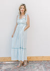 Model wearing heels and a blue and cream striped maxi with blue piping trim and tie straps. 
