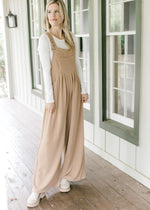 Model wearing a light brown jumpsuit with a ribbed material, pouch pocket and wide legs. 