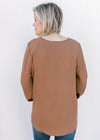 Back view of Model wearing a brown top with a v-neck, 3/4 bubble sleeves and a polyester material. 