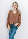 Model wearing a brown polyester top with a v-neck, 3/4 bubble sleeves and an oversized fit. 