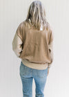 Back view of Model wearing a cream, camel and taupe sweater with long sleeves and 1/4 zipper. 
