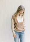 Model wearing a cream, camel and taupe sweater with a ribbed detail, long sleeves and 1/4 zipper. 