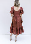 Back view of Model wearing a wine midi dress with a ribbed bodice, short puff sleeves and pockets. 