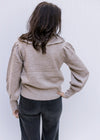Back view of Model wearing a taupe sweater with an exaggerated collar and long sleeves. 