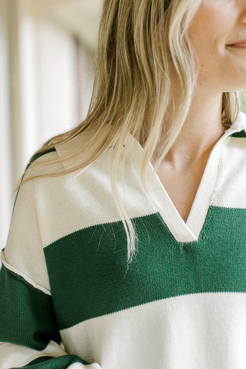 Close up of v-neck and exaggerated collar on a green and cream long sleeve sweater. 