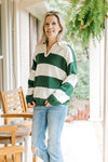 Model wearing jeans with a green and cream striped sweater with long sleeves and a collar. 