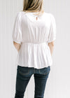 Back view of ivory babydoll  top with a keyhole close and bubble short sleeves.  