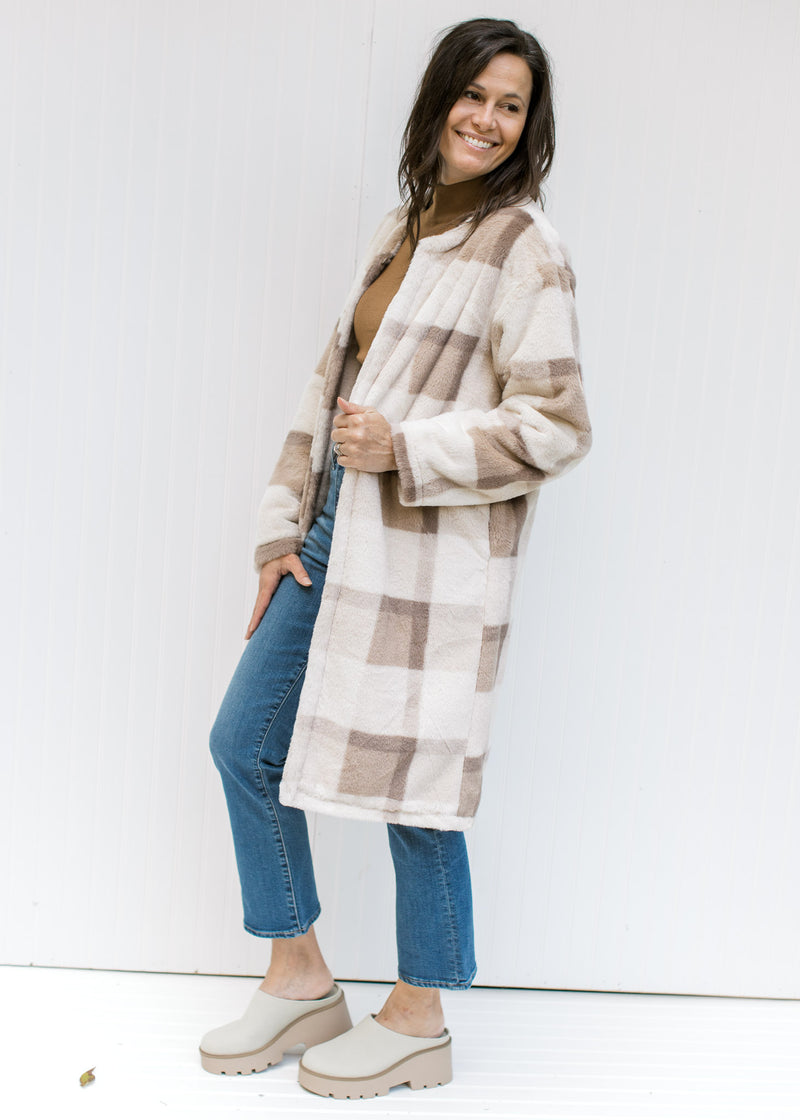 Model wearing a cream, tan and brown plaid knee length coat with pockets and an open front. 
