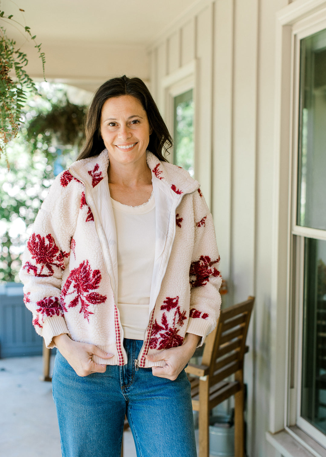 Model wearing a cozy jacket with cream with burgundy floral, zipper, mock neck and long sleeves. 