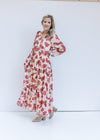 Model wearing booties with a cream maxi with rust floral pattern, long sleeves and v-neck.