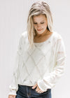 Model wearing a cream crop fit sweater with diamond open stitch detail, long sleeves and round neck.
