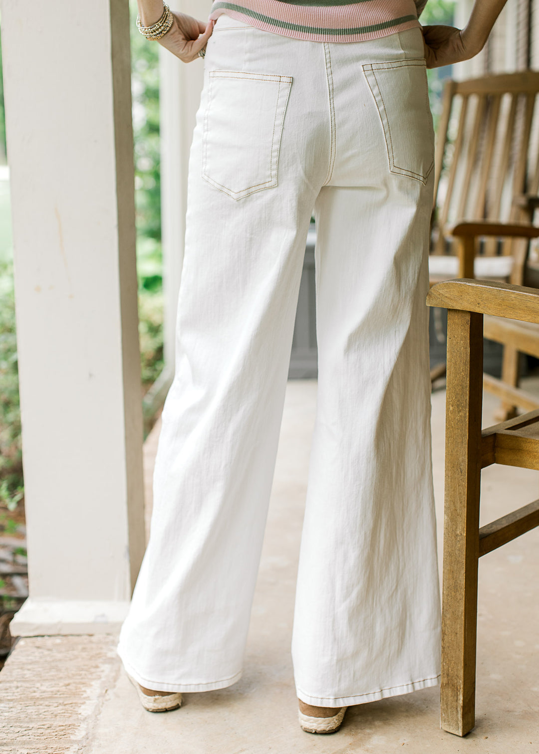 Back view of Model wearing creamy denim wide-leg pants with back pockets. 