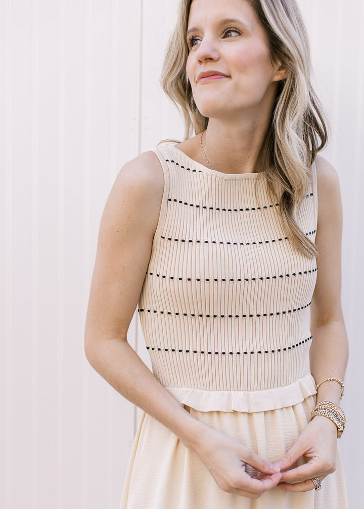 Close up of cream ribbed, smocked, sleeveless sweater with black stripes and attached midi skirt.