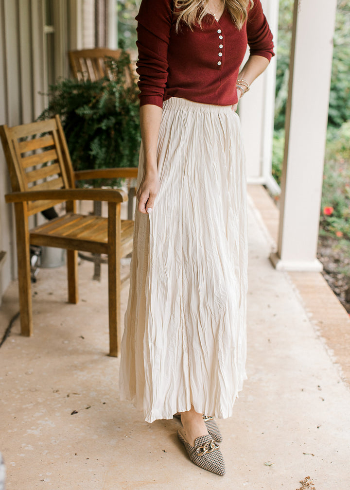 Model wearing a creamy white maxi with crinkle fabric, elastic waistband and a full lining. 