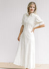 Model wearing a cream embroidered midi with a scalloped collar and button closure on short sleeve.