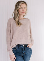 Model wearing a cream sweater with popcorn knit, round neck and long sleeves. 
