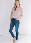 Model wearing jeans, mules and a cream sweater with popcorn knit, round neck and long sleeves.