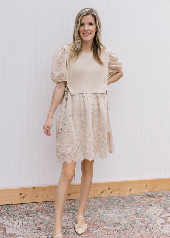 Model wearing flats and a pale coffee cut lace dress with attached sweater vest with side ties. 