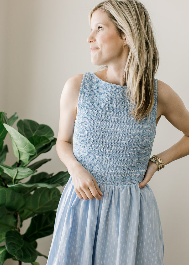Close up of smocked bodice on a soft blue sleeveless maxi with full lining and a round neck. 