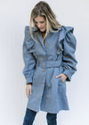 Model wearing a vintage blue coat with a ruffle at the shoulder, belt at wasit and long sleeves. 