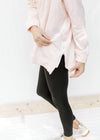 Detail view of zipper on the side of a blush colored sweatshirt with long sleeves and a hood. 