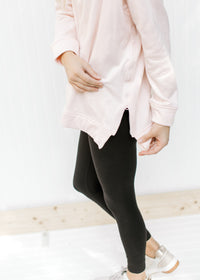 Detail view of zipper on the side of a blush colored sweatshirt with long sleeves and a hood. 