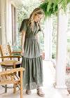 Model wearing wedges with an olive maxi with an elastic waist and short sleeves. 