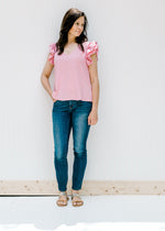 Model wearing jeans and sandals with a polyester pink v-neck top with tiered ruffle short sleeves. 