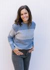 Model wearing a light blue and white color block, ribbed sweater with long sleeves. 
