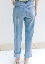 Back view of model wearing medium washed relaxed straight leg jeans. 