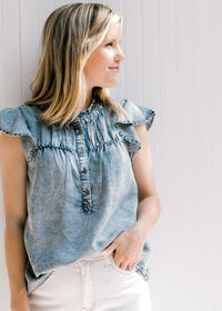 Blonde model wearing white jeans with an acid washed denim top with short sleeves and button front. 