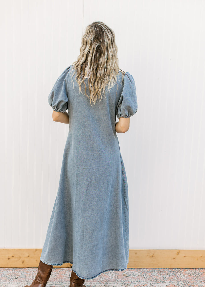 Back view of Model wearing a medium colored denim midi with bubble short sleeves.