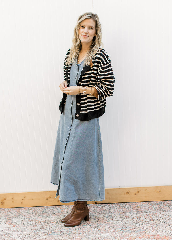 Model wearing stripped cardigan, boots and a denim midi with v-neck and button front. 