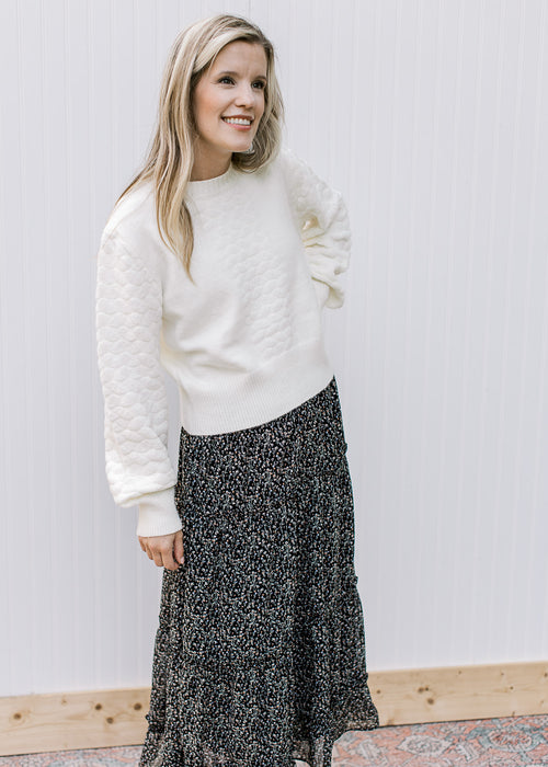 Model wearing a black midi with white ditsy flowers, elastic waist and pockets. 