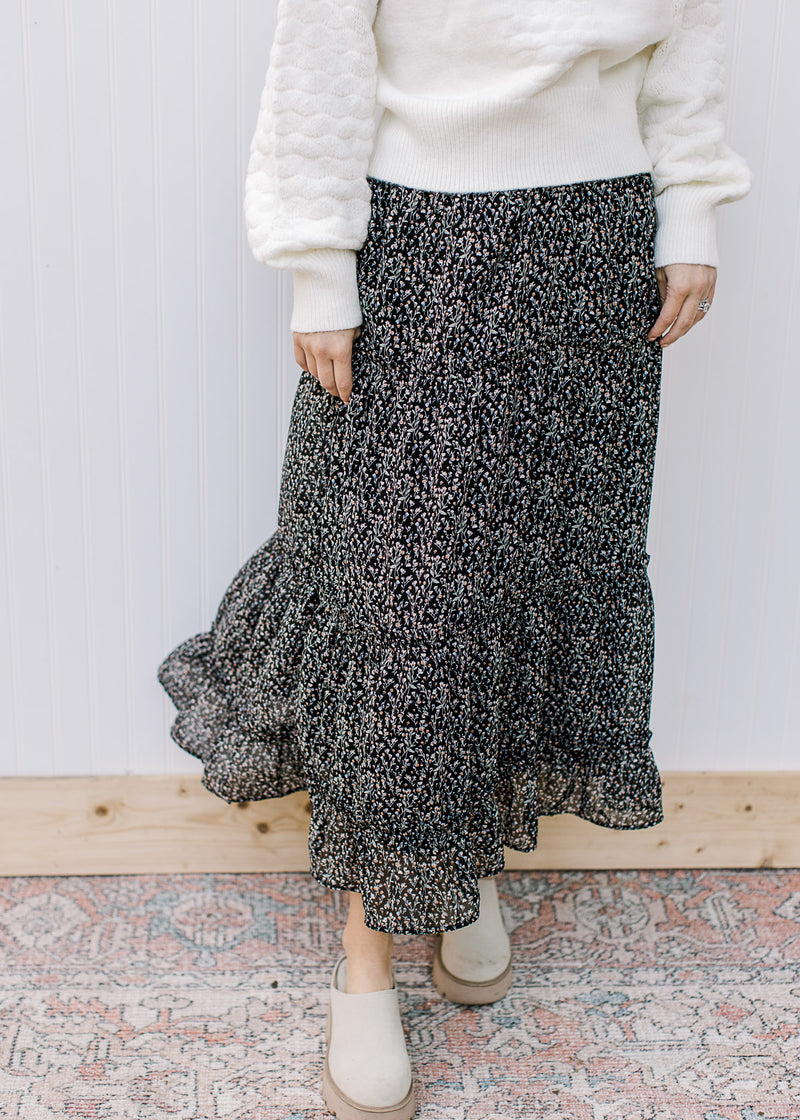 Model wearing a black lined midi with white ditsy flowers, elastic waist and pockets. 