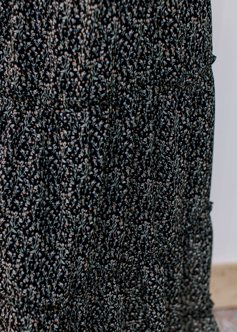 Close up of tiers on a black midi with ditsy flowers, polyester material and elastic waist. 